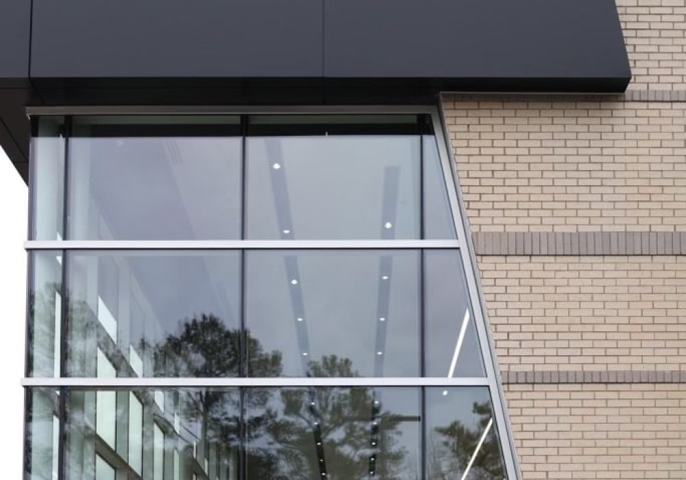 A close-up of the glass-panel architecture of the Kia showroom, reflecting the dealership's contemporary style.