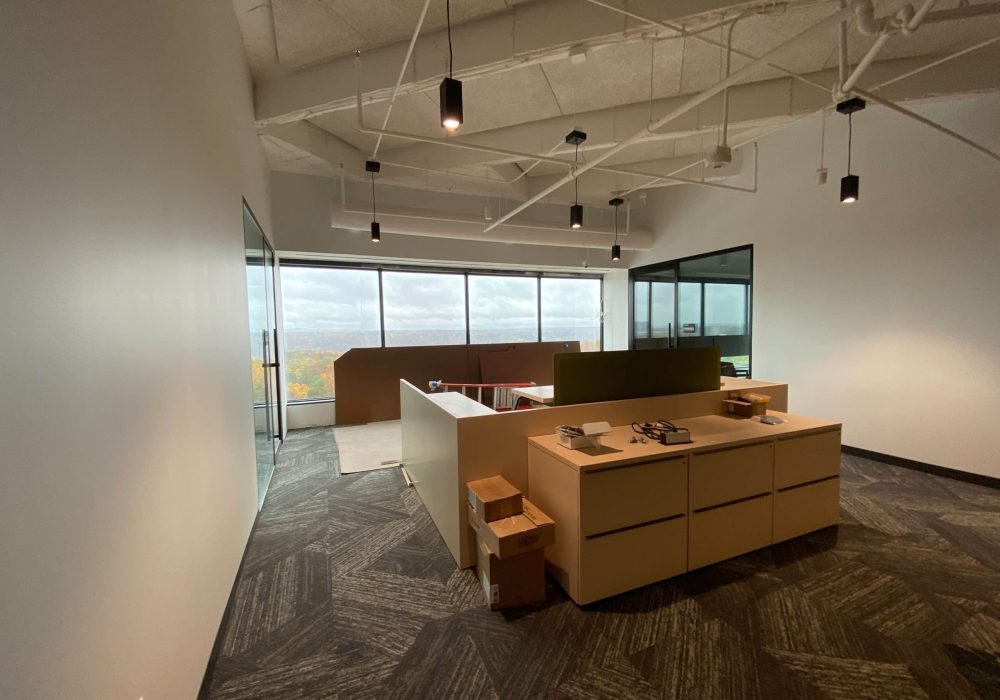 Private office space with a minimalist design, featuring large windows with a scenic city view.