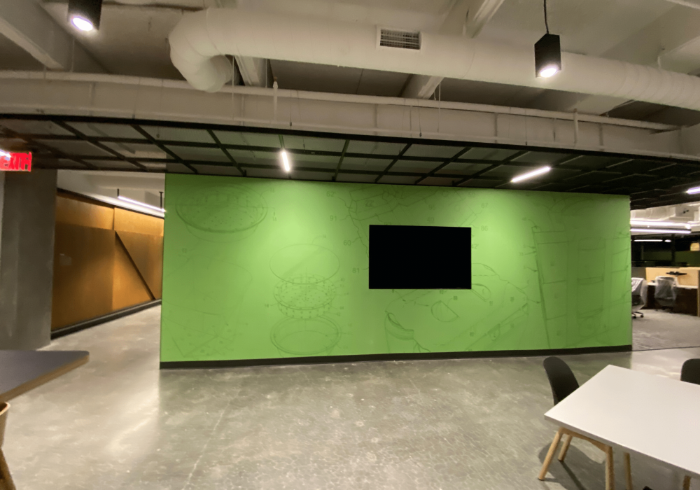 Graphic Packaging International lobby area with a green feature wall, company logo display, and industrial ceiling.