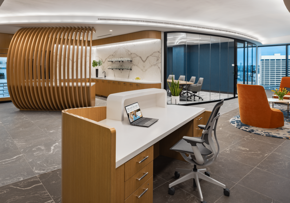 A stylish reception area featuring a curved wooden desk, comfortable seating, and a large digital screen showcasing the Atlanta skyline.